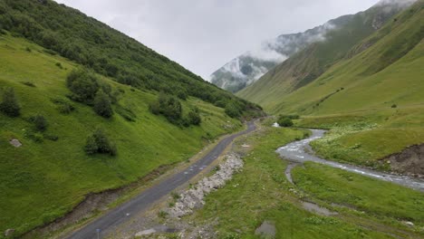 Disparo-De-Drone-Del-Río-De-La-Carretera-Del-Pueblo-Del-Valle-Y-La-Nube-En-El-Cielo-Montañas-Caucásicas