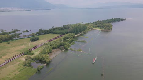 The-footage-shows-a-ferry-travelling-along-the-shores-of-the-Haishe-Ecological-Park,-a-nature-preservation-site-with-diverse-ecosystems