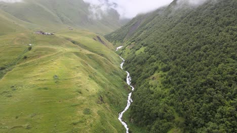 Drohnenaufnahme-Eines-Flusses,-Umgeben-Von-Bergen-Und-Nebel