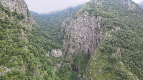 Aerial-shot-of-green-rock-mountains-with-fog