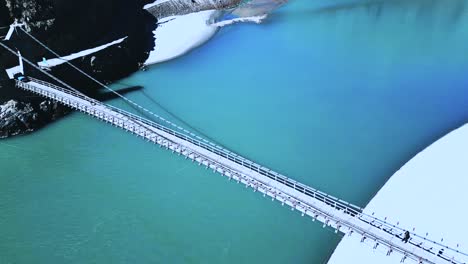 Eine-Hängebrücke-Im-Skardu-Tal---Fluss-Mit-Blauem-Wasser-Und-Die-Drohne-Schwebt-über-Der-Brücke