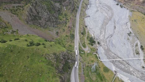 Draufsicht-Auf-Eine-Straße-Inmitten-Von-Bergen,-An-Denen-Lastwagen-Und-Autos-Vorbeifahren