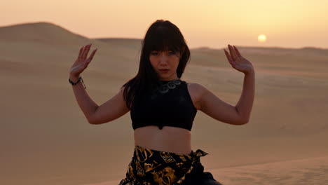 Woman-throwing-sands-in-Sahara-Desert-at-sunset-with-sand-dunes-in-background