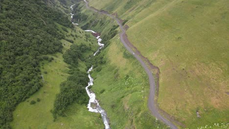 Toma-De-Drone-De-Una-Carretera-Y-Un-Río-Rodeados-De-Montañas-Caucásicas