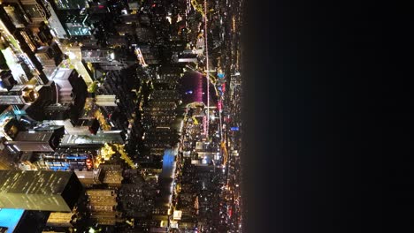 Vertical-establishing-aerial-shot-of-Huangpu-district-and-the-west-bund-in-Shanghai-downtown-at-night-time,-China