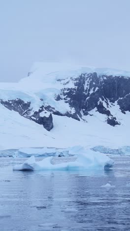 Icebergs-Y-Montañas-Azules-De-La-Antártida,-Iceberg-Flotando-En-El-Agua-Del-Océano-En-Video-Vertical-Para-Redes-Sociales,-Carretes-De-Instagram-Y-Tiktok,-Paisaje-Marino-De-Hielo-Invernal-De-La-Península-Antártica