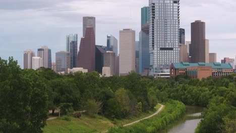 Aufsteigende-Drohnenaufnahme-Des-Buffalo-Bayou-Und-Enthüllung-Der-Innenstadt-Von-Houston,-Texas