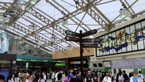 Animada-Estación-De-Tren-En-Japón-Con-Viajeros-Bajo-Un-Gran-Techo-De-Cristal.