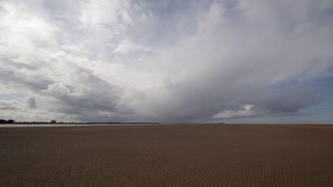 Extra-Weite-Aufnahme-Eines-Flachen-Strandes-Mit-Stürmischen-Gewitterwolken