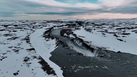 High-above-Selfoss-Waterfall,-Iceland,-an-orbiting-drone-shot-reveals-the-cascading-waters-framed-by-rugged-Icelandic-terrain