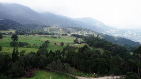 Vista-Lateral-Aérea-Del-Paisaje-Brumoso-De-Un-Lugar-Situado-Entre-Colinas