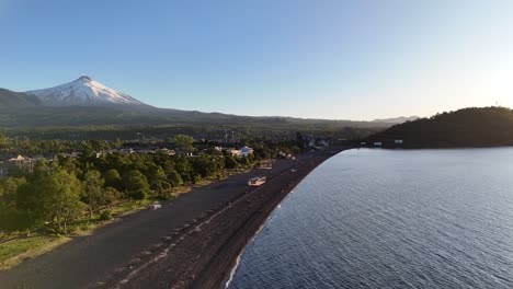 Vista-Aérea-De-Las-Playas-De-Arena-Negra-Del-Lago-Villarrica,-El-Volcán-Al-Fondo