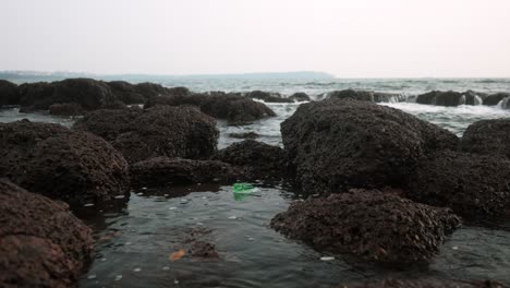 Ocean-waves-crash-against-rocky-shore-at-sunrise,-a-serene-coastal-scene-captured-in-close-up