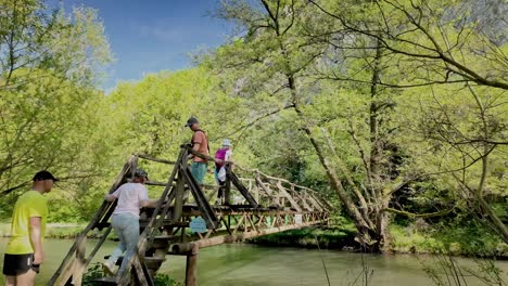 Familie-Erkundet-Den-Fluss-Zlatna-Panega-über-Eine-Rustikale-Holzfußgängerbrücke