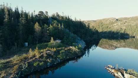 Cabin-Surrounded-By-Lush-Trees-On-Shore-Of-Mjovatnet-Lake-In-Indre-Fosen,-Norway