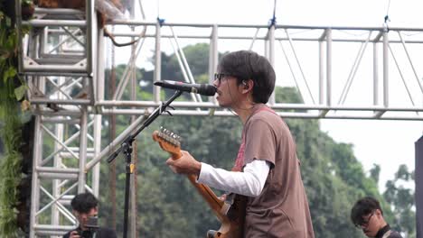 Fiersa-Besari-Famoso-Cantante-Indonesio-Cantando-En-El-Escenario-Con-Una-Banda-Durante-El-Festival-De-Música