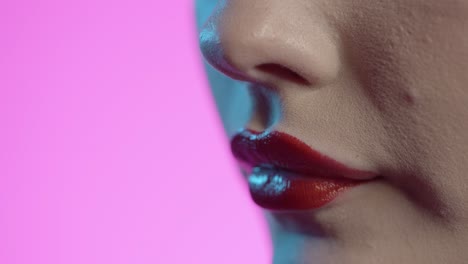 woman-licking-her-lips,-red-lipstick,-pink-background