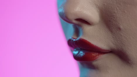 Mujer-Lamiéndose-Los-Labios,-Lápiz-Labial-Rojo,-Fondo-Rosa