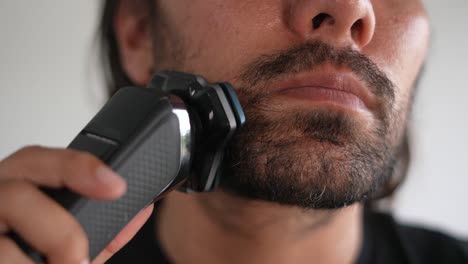 Latino-man-trimming-beard-and-mustache-with-electric-razor,-Clipper