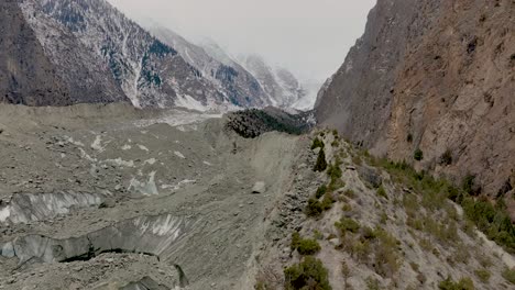 Aerial-View-Over-Ridgeline-with-desolate-mountain-environment-with-a-cloudy,-overcast-sky-suggesting-a-remote-or-harsh-location