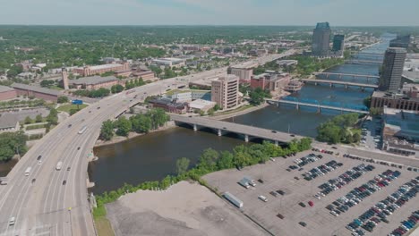 Freeway-in-Grand-Rapids,-Michigan-with-drone-video-panning-to-skyline