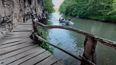 Tourist-boat-trip-passes-wooden-boardwalk-Zlatna-Panega-River-eco-path