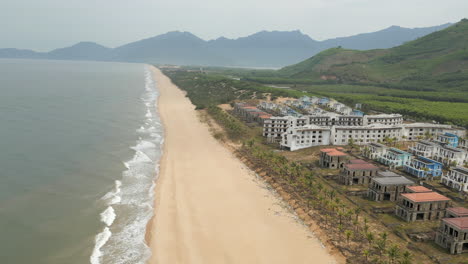 Vietnamesisches-Geisterhotel-In-Der-Region-Lang-Co,-Während-Eine-Drohne-Den-Einsamen-Strand-Entlangfährt