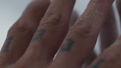 extreme-close-up-of-tattooed-fingers-hands-while-praying-for-life-during-a-sand-storm