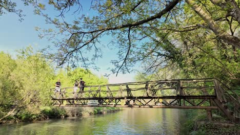Zltana-Panega-Eco-path-walkers-cross-scenic-wooden-river-footbridge