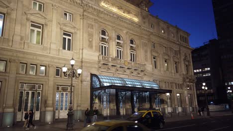 Puerta-De-Entrada-Del-Edificio-Icónico-Del-Teatro-Colon-Con-Tráfico-En-La-Avenida-9-De-Julio-Buenos-Aires-Argentina-Vida-Nocturna