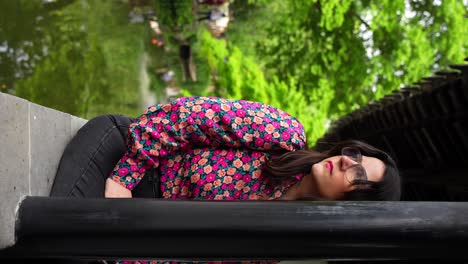 Woman-with-floral-shirt-sitting-and-admiring-a-Chinese-garden