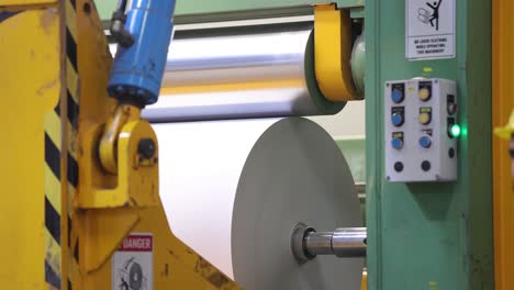 A-roll-of-prepared-paper-is-being-made-inside-a-big-machine