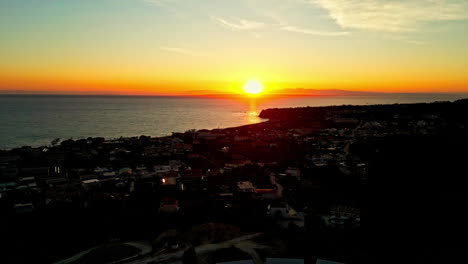 Sonnenuntergang-über-Einer-Küstenstadt-Mit-Leuchtenden-Farben,-Die-Den-Himmel-Und-Das-Meer-Erhellen