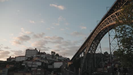 Dom-Luís-I-Bridge-and-Porto's-hillside-buildings-at-dusk-under-a-pastel-sky,-Portugal