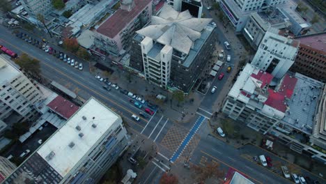 Aerial-topdown-view-over-Sun's-Pyramid-building-at-Providencia-neighborhood-corner,-Santiago-de-Chile