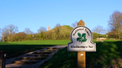 Una-Vista-De-La-Popular-Atracción-Turística-De-Tor-Con-Un-Cartel-De-Confianza-Nacional-En-Los-Niveles-De-Somerset-En-Glastonbury,-Inglaterra,-Reino-Unido.