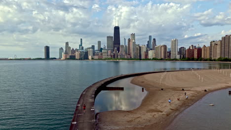 Aerial-view-rising-in-front-of-people-at-the-North-Avenue-Beach,-summer-in-Chicago