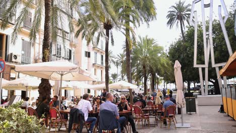 Gente-Sentada-En-Un-Restaurante-Al-Aire-Libre-En-Una-Calle-De-Palma-En-Mallorca