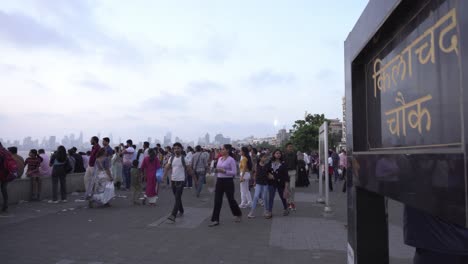 Crowd-of-people-at-Marine-Drive-sunset-Point,-Kilachand-Chowk-signage-in-South-Mumbai