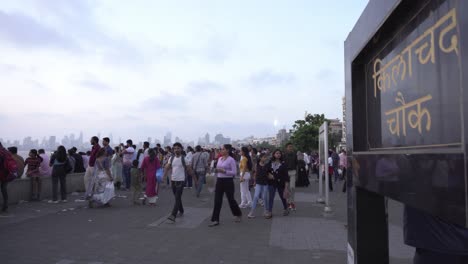 Multitud-De-Personas-En-Marine-Drive-Sunset-Point,-Señalización-De-Kilachand-Chowk-En-El-Sur-De-Mumbai