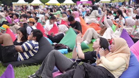 Indonesier-Beim-Outdoor-Festival-Liegen-Auf-Sitzsäcken-Auf-Dem-Rasen-Und-Applaudieren