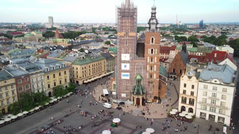 Basilica-of-Saint-Mary-tower-restoration-construction,-Main-Market-Square-in-Krakow-surrounded-by-buildings