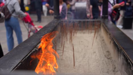 Chinesen-Legen-Räucherstäbchen-Ins-Feuer