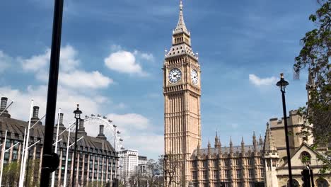 Big-Ben-and-the-Houses-of-Parliament-in-London-on-a-sunny-day,-featuring-clear-blue-skies-and-nearby-buildings