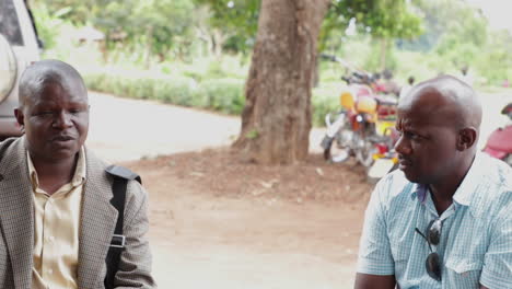 Two-men-having-a-conversation-outdoors-in-Kampala,-Uganda