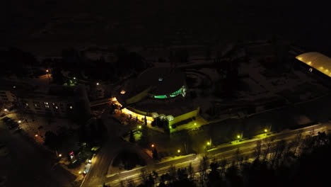 Aerial-orbit-shot-in-front-of-a-the-Tropiclandia-waterpark,-night-in-Vaasa,-Finland