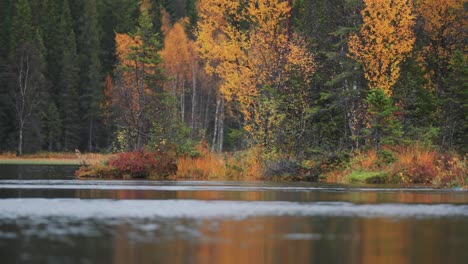 Lebendige-Farbtöne-Eines-Herbstwaldes-Entlang-Der-Ufer-Eines-Schneebedeckten-Flusses,-Die-Ein-Dynamisches-Und-Faszinierendes-Schauspiel-Saisonaler-Schönheit-Schaffen