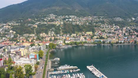 Establishing-aerial-of-Locarno-town-lake-marina-in-Switzerland,-drone-view