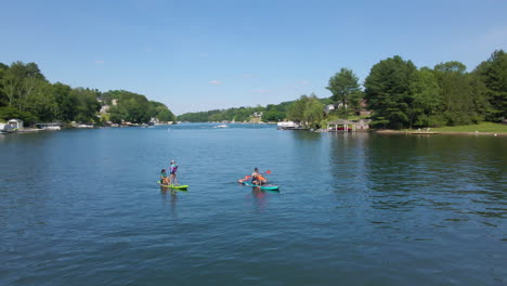Women-and-Child-Ride-Paddle-Boards-on-Lake-in-Rural-Pennsylvania,-USA