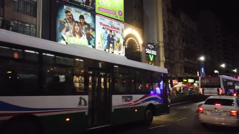 Traffic-drive-through-Corrientes-Avenue,-Theaters,-commercial-banner-displays